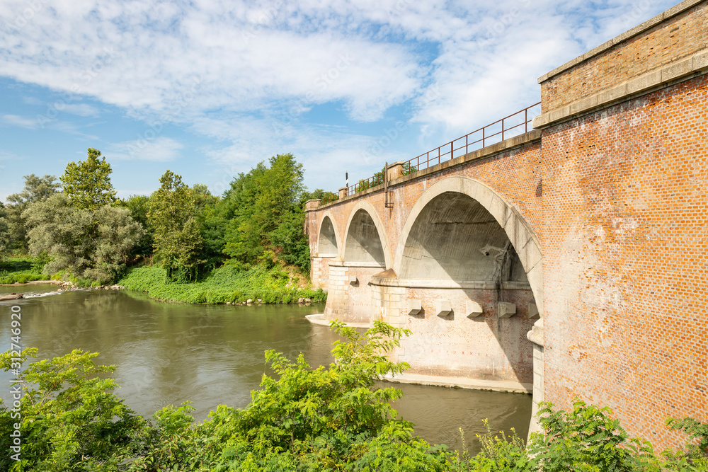 Fototapeta premium old railway bridge over Lambro river next to Lambrinia village (Chignolo Po), Province of Pavia, Lombardy, Italy