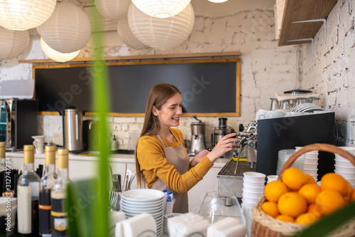 Professional barista cleaning her espresso coffee machine photo