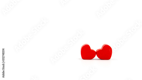 Two little red hearts hugging each other. Lots of empty space.