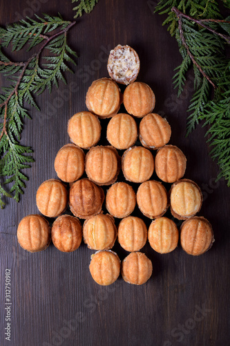 Walnut shaped cookies Oreshki forming a Christmas tree on the dark wooden background