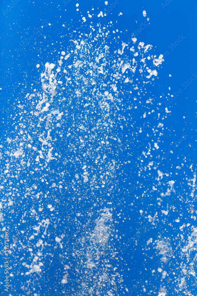 Splashing water from a fountain on a background of blue sky Splashing water from a fountain on a background of blue sky