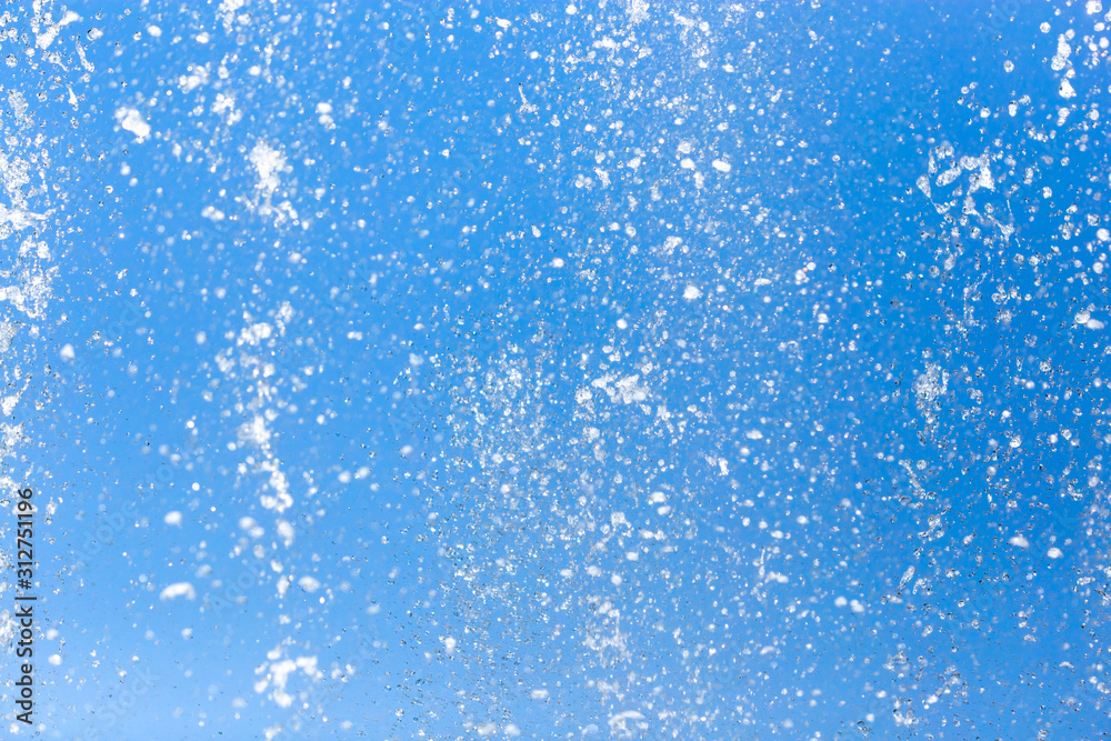 Splashing water from a fountain on a background of blue sky Splashing water from a fountain on a background of blue sky
