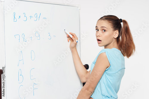 student writing math equations on whiteboard