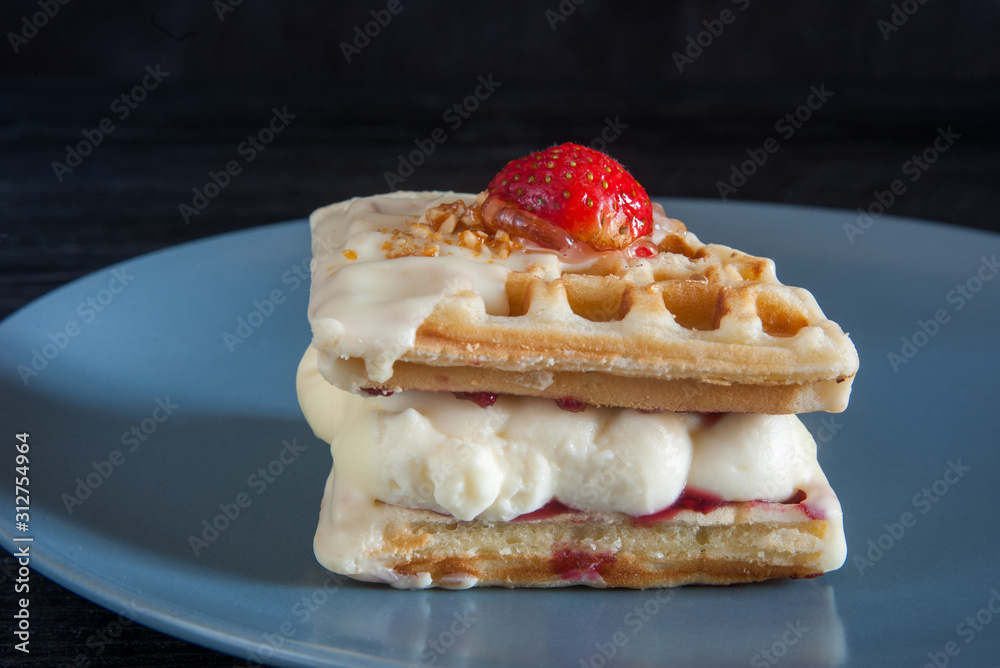 Belgian waffle cake on gray plate on black background Belgian waffle cake on gray plate on black background