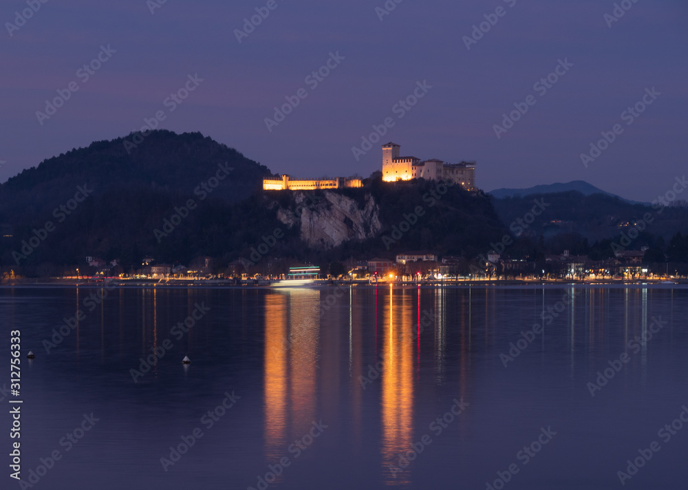 the Lombard shore of Lake Maggiore and the Borromea fortress at night time viewed from Arona.Italy