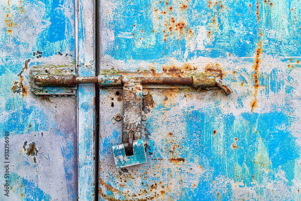 Blue padlock on a rusty metallic blue door Blue padlock on a rusty metallic blue door