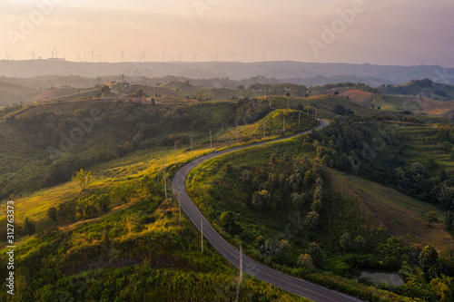 Slope asphalt road in valley with turbine wind on hill