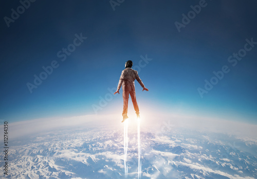 Fotografie, Tablou Businessman in suit and aviator hat flying in sky