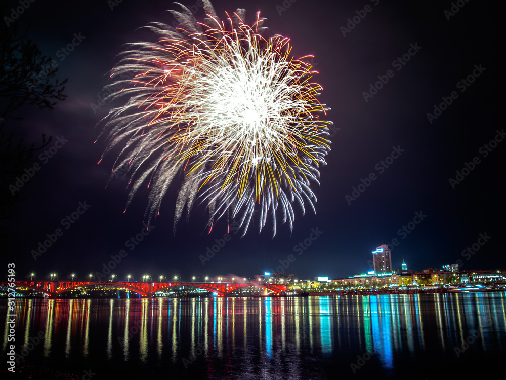 Fireworks in Krasnoyarsk: explosions of golden fireworks over the Yenisei River. Russia. Siberia. Fireworks in Krasnoyarsk: explosions of golden fireworks over the Yenisei River. Russia. Siberia.