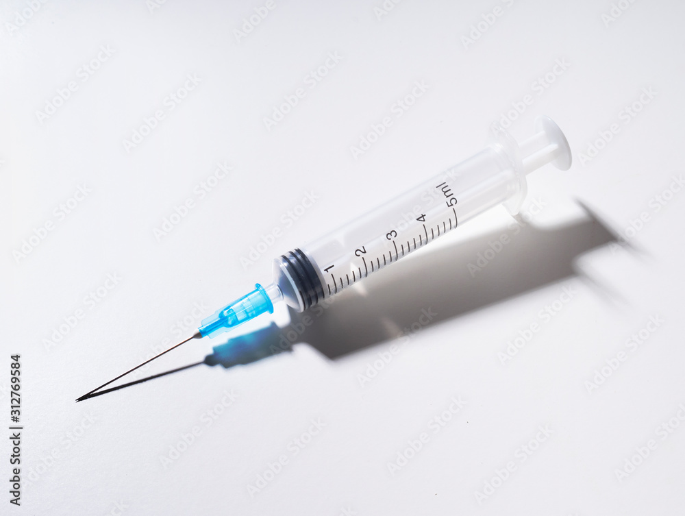 Generic, standard design single use plastic syringe with shadow due to back lighting. White background. Generic, standard design single use plastic syringe with shadow due to back lighting. White background.