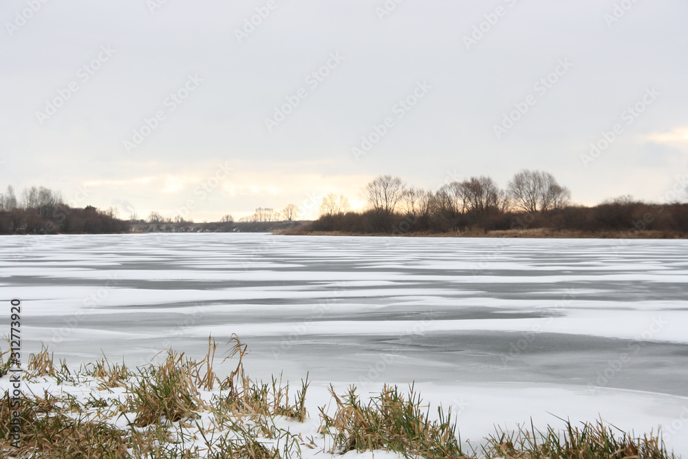Snow on the ice of the river at sunset Snow on the ice of the river at sunset