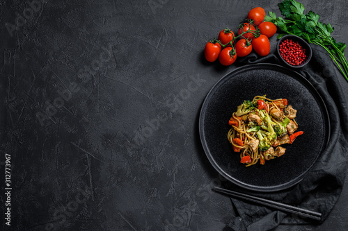 Soba noodles with beef, carrots, onions and sweet peppers. Top view. Dark background. Space for text