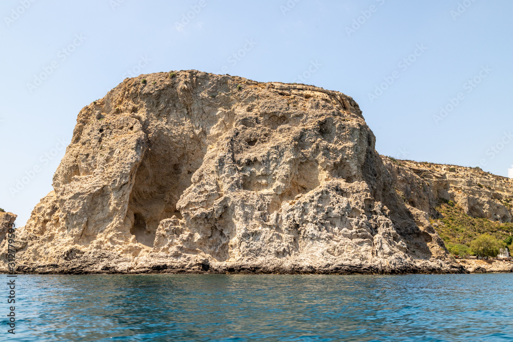 Naklejka premium View from a motor boat on the mediterranean sea at the rocky coastline near Stegna on the eastside of Greek island Rhodes