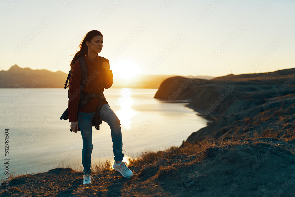 woman walking on the beach at sunset