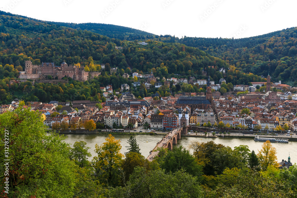 Nice panorama of Heidelberg's old town with the castle on Königstuhl hill, the Church of the Holy Spirit and the Karl Theodor Bridge on the Neckar river viewed from the Philosopher’s Path in autumn. 