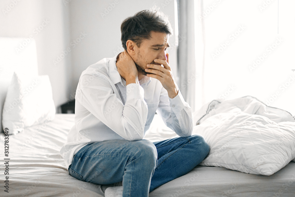 young man sitting on sofa and talking on cell phone young man sitting on sofa and talking on cell phone