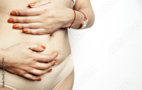 Acute pain woman in belly-ache, close-up isolated on a white background. Pain area of red color. hands touch the painful point. Healthcare and medical concept