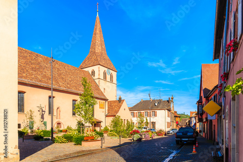 Beautiful church and traditional colorful houses in picturesque Kientzheim village, Alsace wine region, France photo