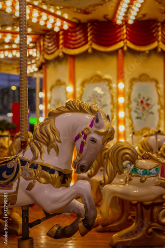 Horses to sit in a street festive carousel. Mass festivities and fun. Close-up. Vertical.