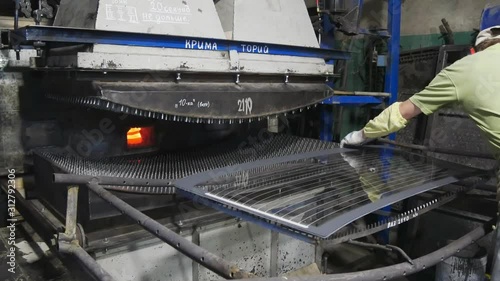 Worker puts the glass sheet on the frame.The production of stalinite. photo