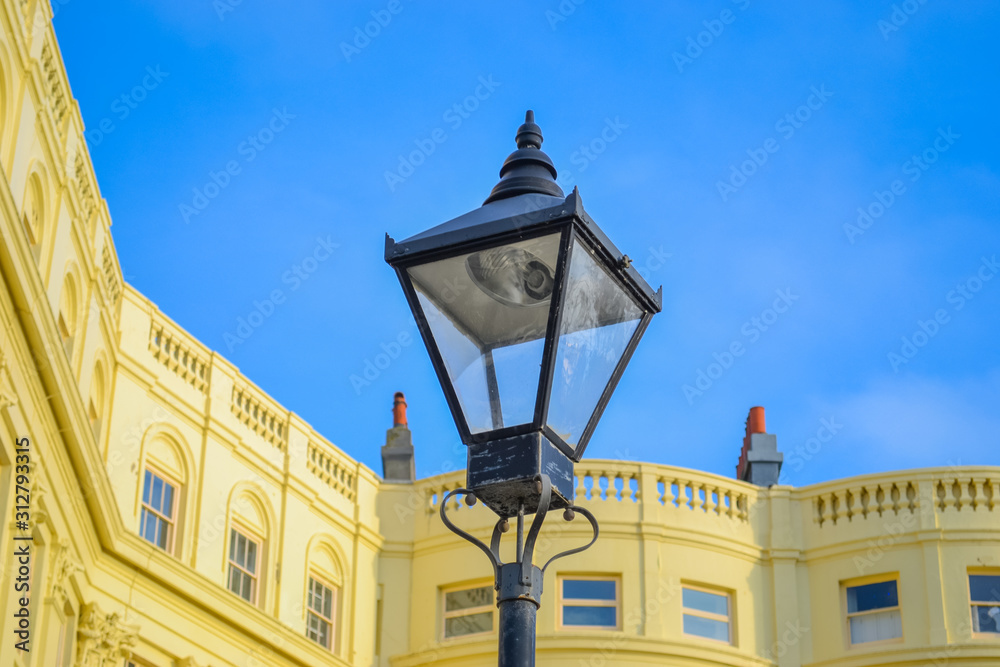 Hove, UK, 29/12/2019: Street lamp against the background of a yellow Victorian style building