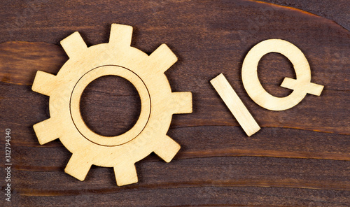 Intelligence quotient, iq test, brain concept, gear with letters on a brown wooden background