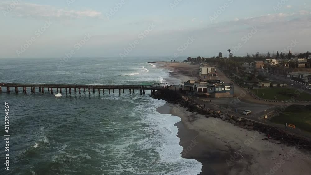 4K aerial drone video of Namibian Atlantic coastline, Swakopmund vintage buildings, town panorama, beach, old Jetty pier, landscape with ocean background of holiday resort at Namibia's west coast 4K aerial drone video of Namibian Atlantic coastline, Swakopmund vintage buildings, town panorama, beach, old Jetty pier, landscape with ocean background of holiday resort at Namibia's west coast