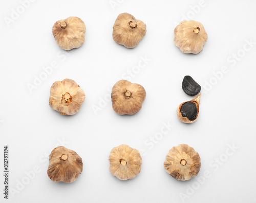 Black garlic on white background. Concept of uniqueness