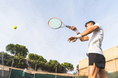 Young Man Playing Tennis Outdoors. © MCStock