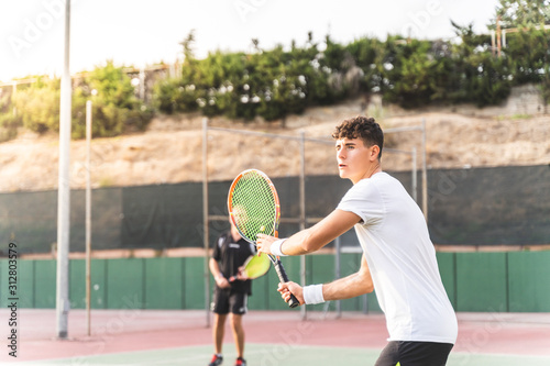 Two Men Playing Tennis as a Team Outdoors.