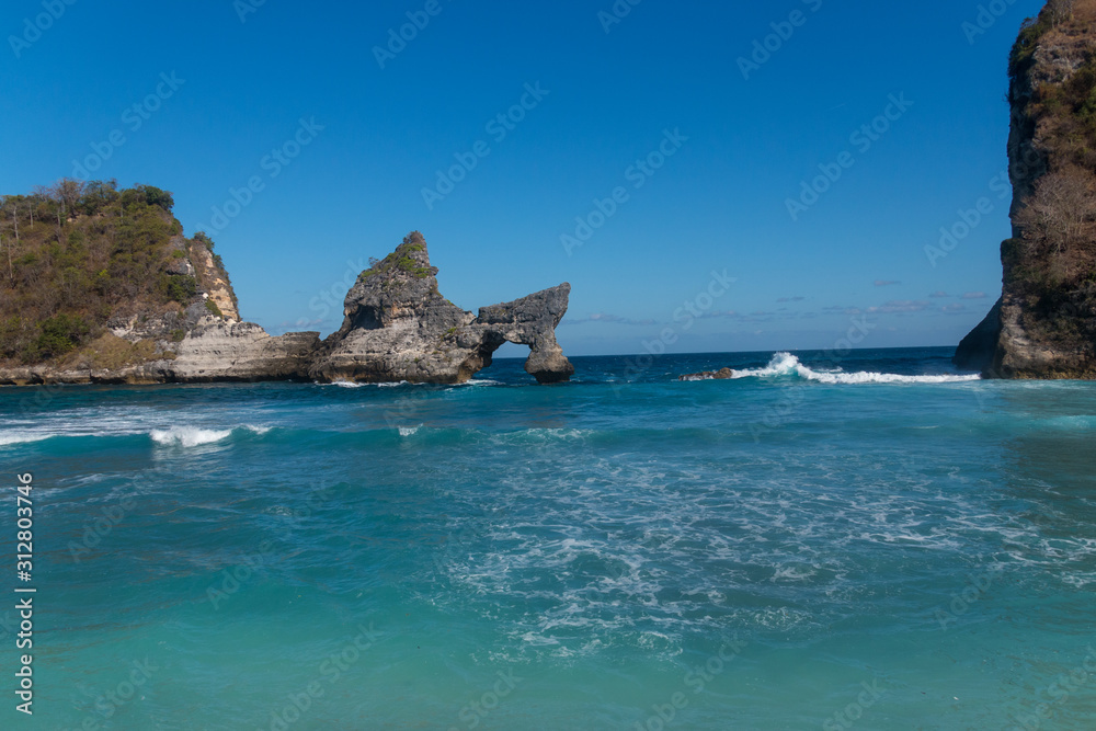 Atuh Beach With Famouse Rock Island Outcrop and Natural Arch Carved By The Bright Turquoise Ocean on Nusa Penida, Bali, Indonesia
