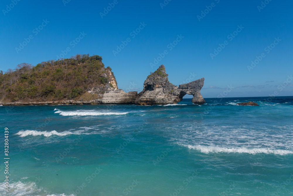 Atuh Beach With Famouse Rock Island Outcrop and Natural Arch Carved By The Bright Turquoise Ocean on Nusa Penida, Bali, Indonesia Atuh Beach With Famouse Rock Island Outcrop and Natural Arch Carved By The Bright Turquoise Ocean on Nusa Penida, Bali, Indonesia