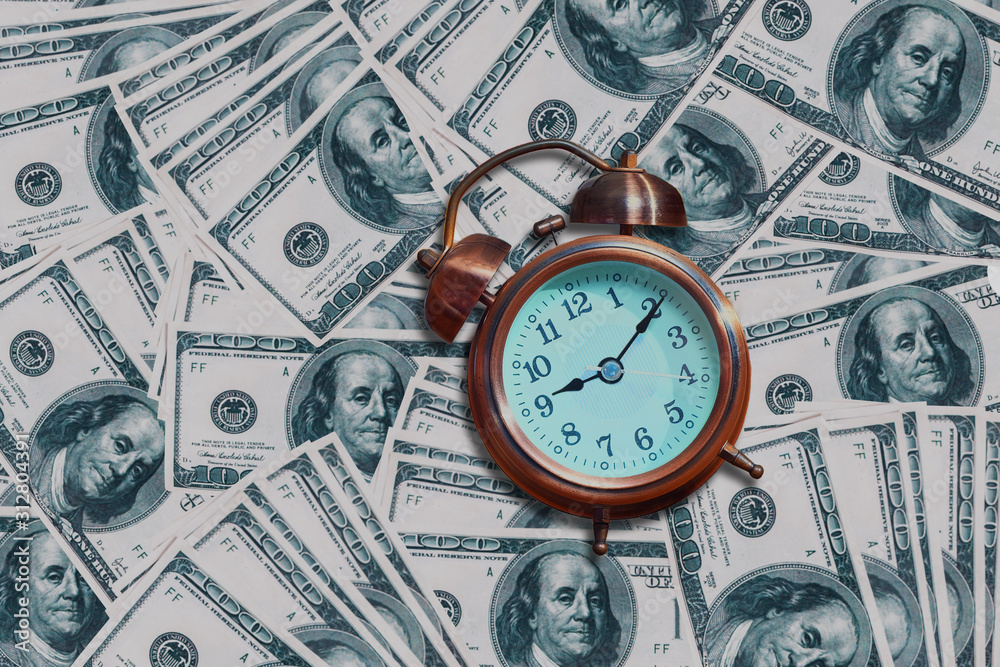An alarm clock on banknote background . Concept for time is money. An alarm clock on banknote background . Concept for time is money.