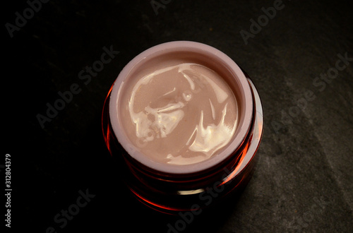 close up jar of light pink face cream