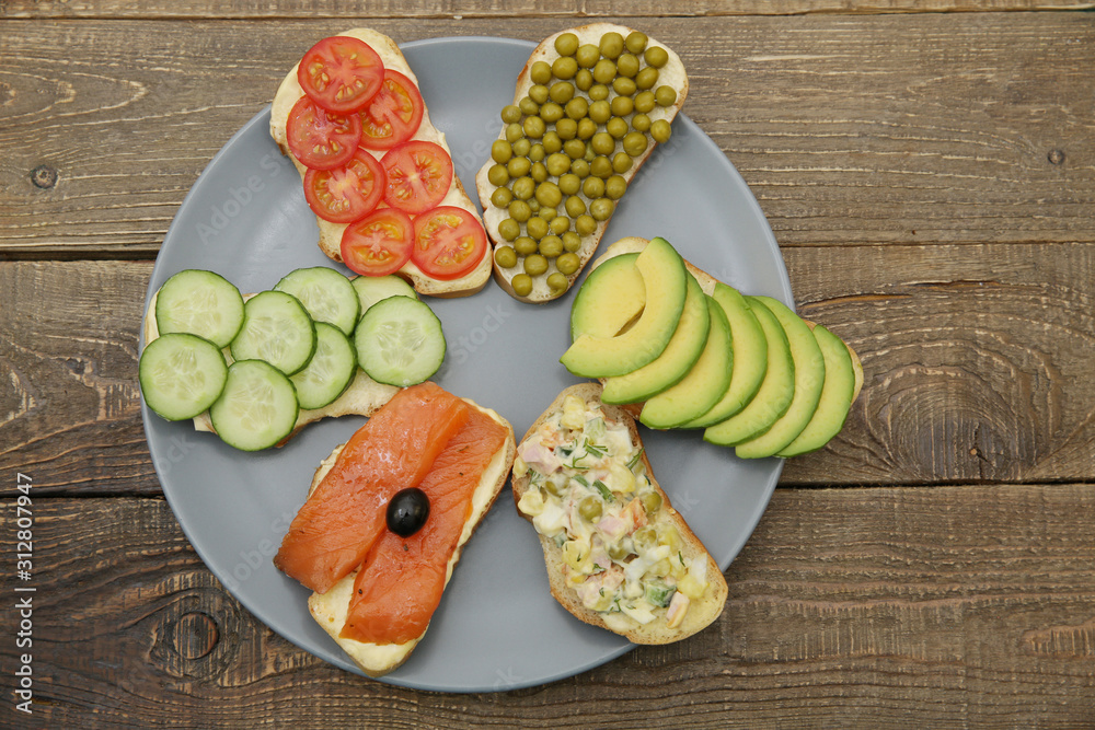 sandwiches or tapas or bruschetta prepared with tasty ingredients. Food for healthy breakfast or lunch or authentic traditional set for lunch table. Flat lay. Top view. Copy space. sandwiches or tapas or bruschetta prepared with tasty ingredients. Food for healthy breakfast or lunch or authentic traditional set for lunch table. Flat lay. Top view. Copy space.