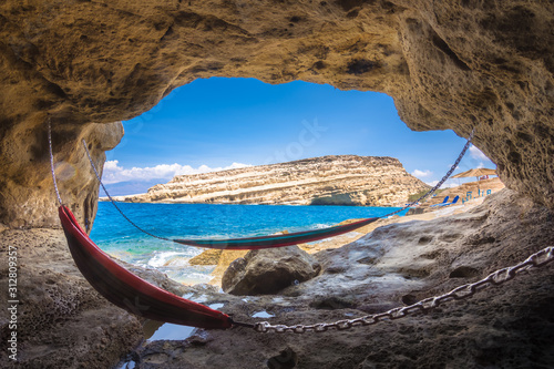 Fototapeta Naklejka Na Ścianę i Meble -  Matala beach with caves on the rocks that were used as a roman cemetery and at the decade of 70's were living hippies from all over the world, Crete, Greece
