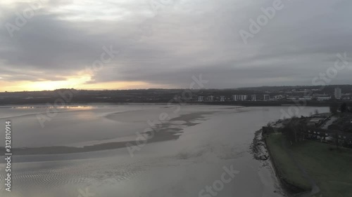 Sunrise waterfront river Mersey canal channel. Pull back aerial dolly left view. photo