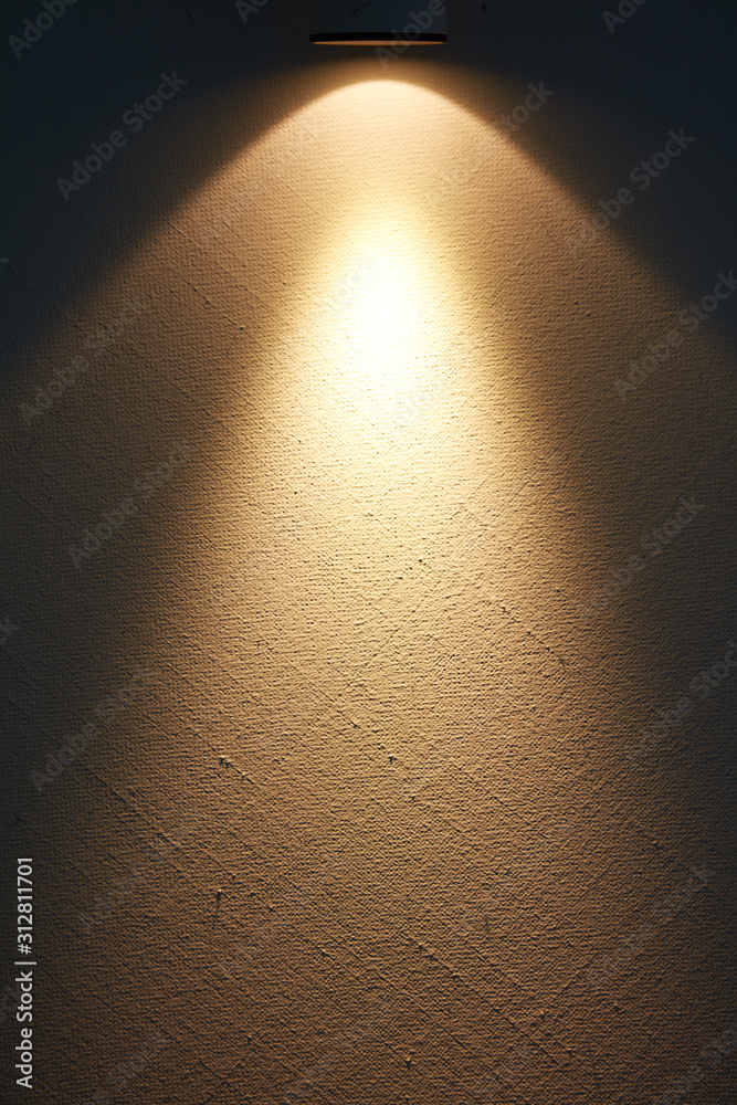 Eine helle Lampe erzeugt einen Lichtstrahl auf einer Wand. Stock 写真 | Adobe  Stock