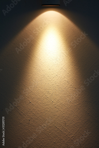 Eine helle Lampe erzeugt einen Lichtstrahl auf einer Wand.