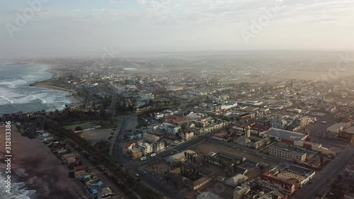 4K aerial drone video of Namibian Atlantic coastline, Swakopmund vintage buildings, town panorama, beach, old Jetty pier, landscape with ocean background of holiday resort at Namibia's west coast