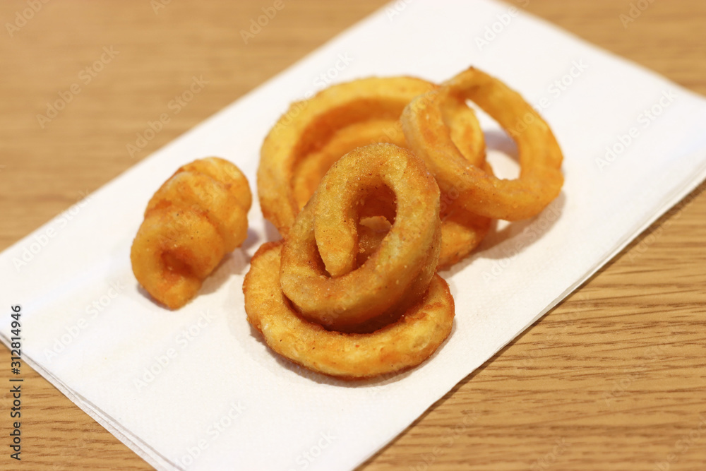 Delicious curly fries on a white paper napkin Delicious curly fries on a white paper napkin