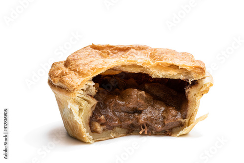 Puff pastry steak pie on baking paper isolated on white photo
