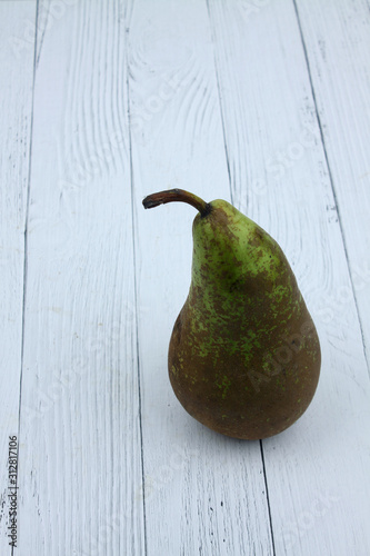 green pear isolated on white wooden backgrond. Vertical image photo