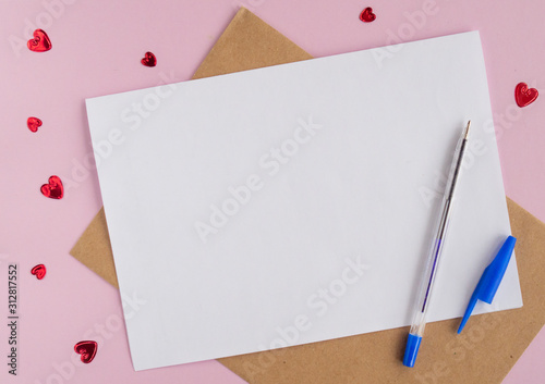 Minimalistic card mockup with envelope, postcard, pen, red hearts on  pink background. Flat lay, top view, copy space. Valentines day concept.