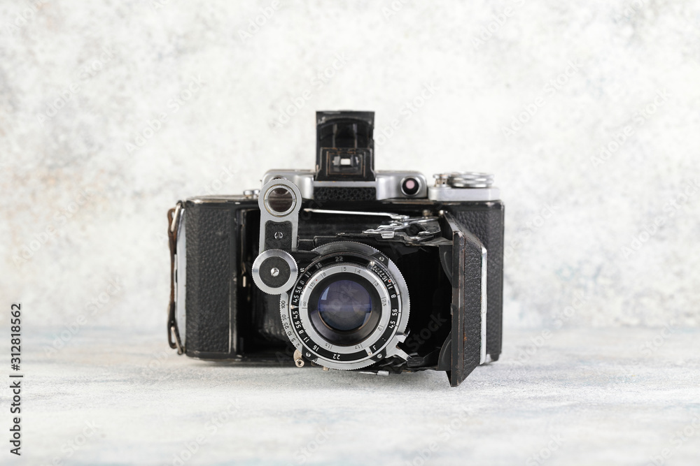 Old medium format rangefinder camera on gray cement background.