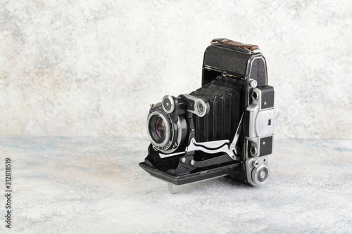Photography Old medium format rangefinder camera on gray cement background.