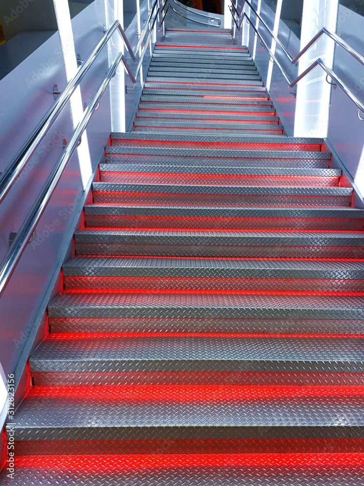 Fototapeta premium Close-up of abstract metal staircase with backlight with blur / side effect. Background for postcards, wallpapers, savers