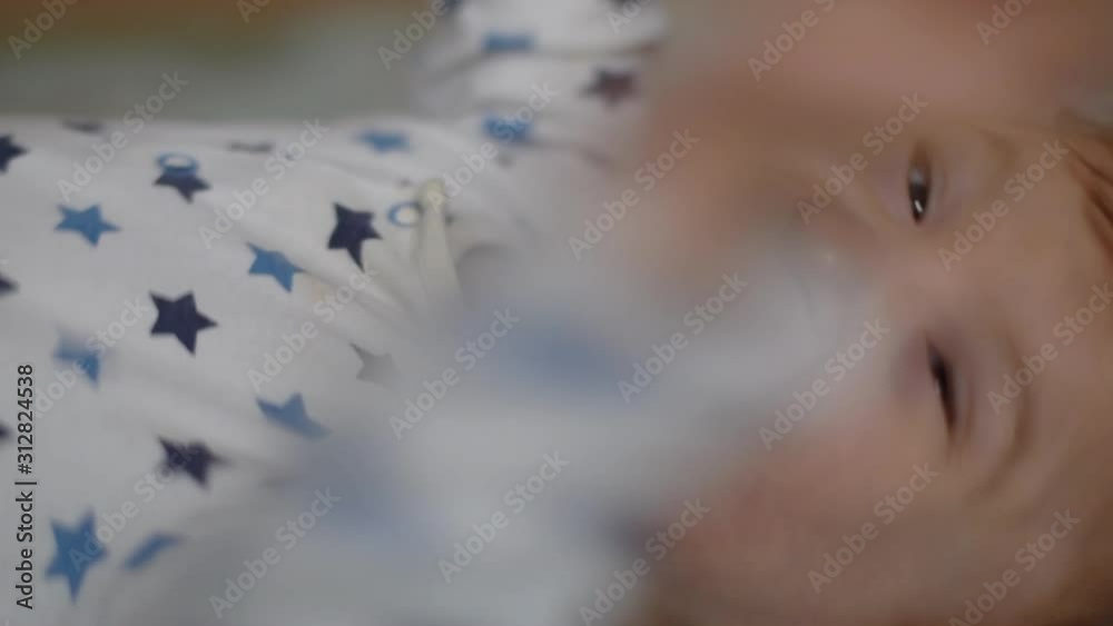 Portrait of a happy baby with cerebral palsy lying on his back and