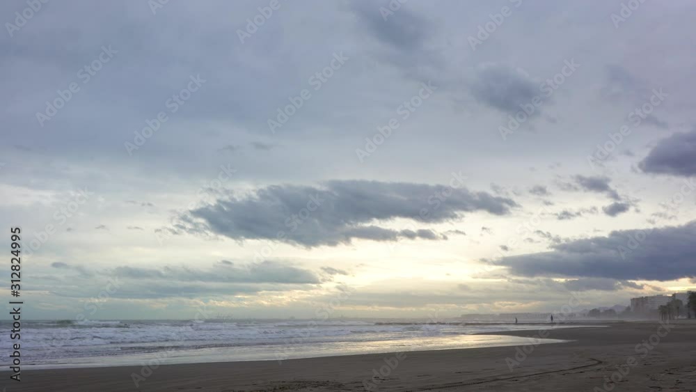 Couple walks on breakwater on the horizon and at sunset Couple walks on breakwater on the horizon and at sunset