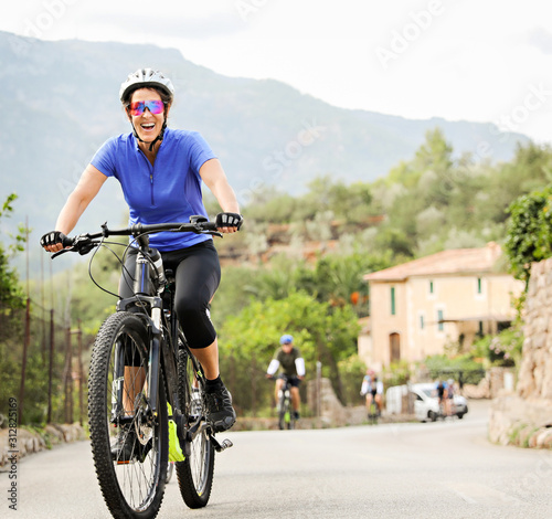 Woman riding an E Bike up a hill in Mallorca. 
